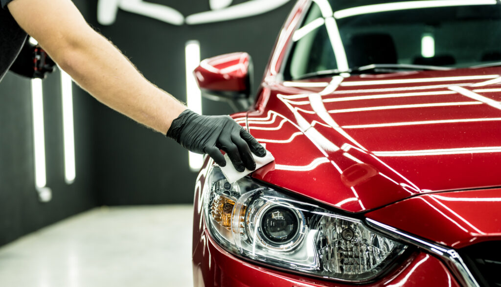 Car service worker applying nano coating on a car detail