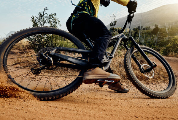 Sports, action and biker dirt racing on mountain bike enjoying riding, cycling and moving with speed. Extreme sports, mountain biking and athlete drifting on dirt road for fitness, adrenaline and fun
